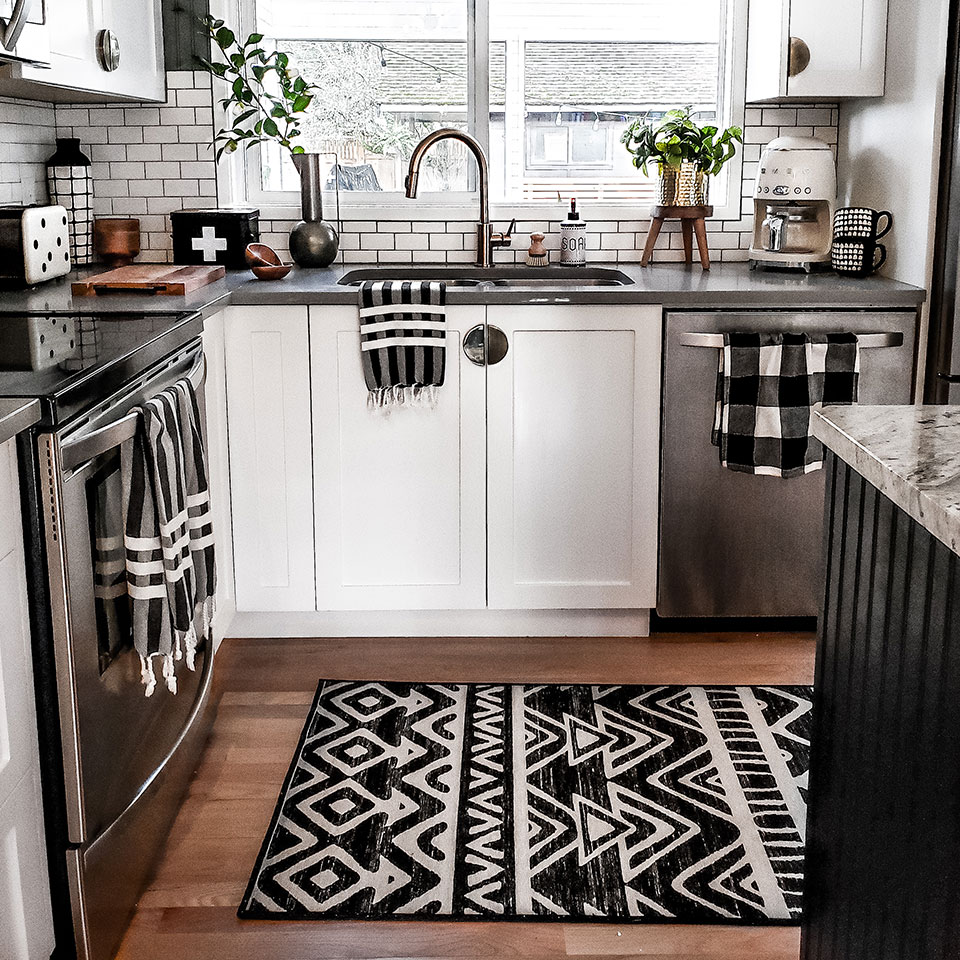 small black and white kitchen with geometric rug