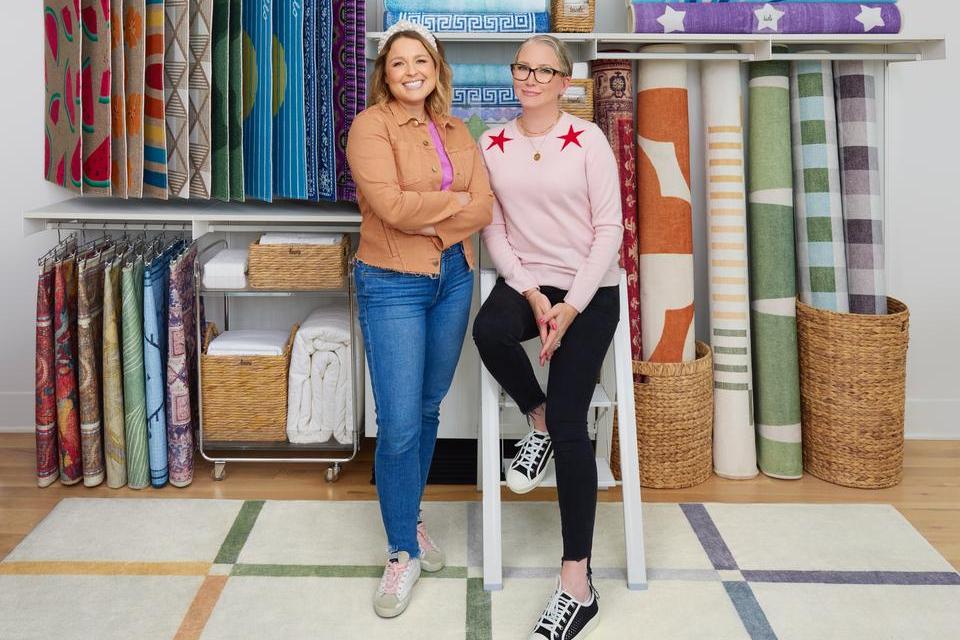 Clea and Joanna pose on a step stool with their collection of washable rugs: Ruggable x The Home Edit