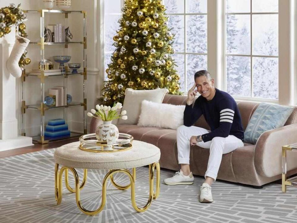 Jonathan Adler poses on a velvet couch to promote his collaboration with Ruggable